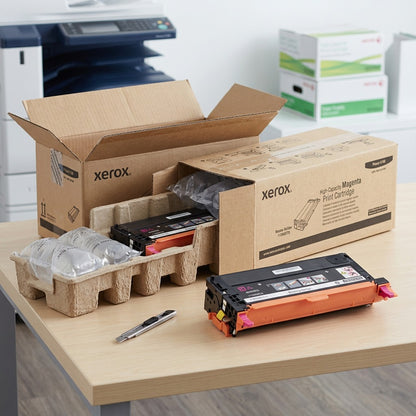 Xerox high-capacity magenta toner cartridge unboxed beside its secure protective packaging.